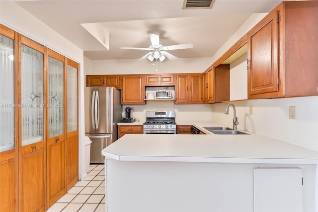 kitchen featuring ceiling fan, stainless steel appliances, kitchen peninsula, and sink