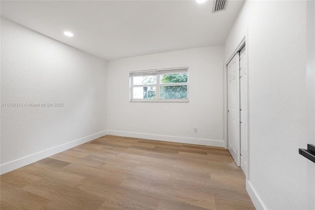 unfurnished bedroom featuring a closet and light hardwood / wood-style flooring