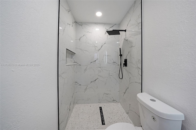 bathroom with toilet and a tile shower