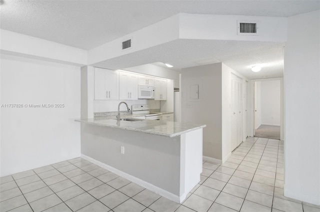 kitchen featuring white appliances, visible vents, a peninsula, light stone countertops, and white cabinetry