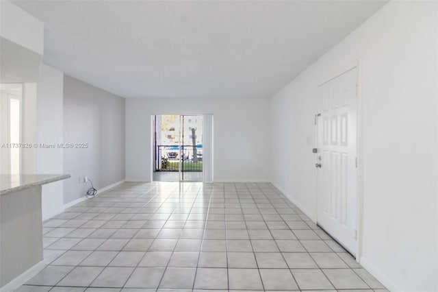 unfurnished room featuring light tile patterned floors and baseboards