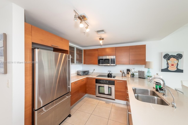 kitchen featuring sink, light tile patterned floors, track lighting, and appliances with stainless steel finishes