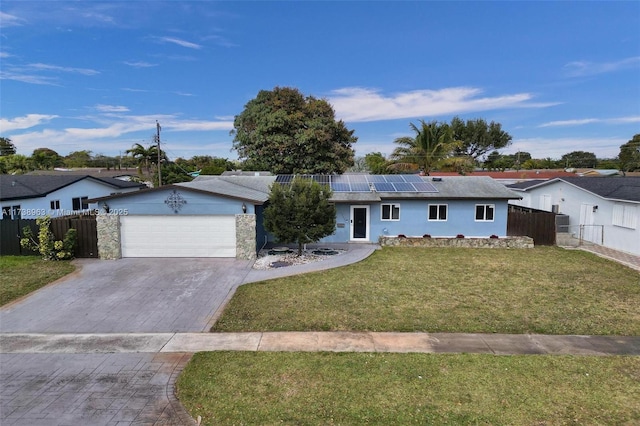 ranch-style house with a garage, a front yard, and solar panels