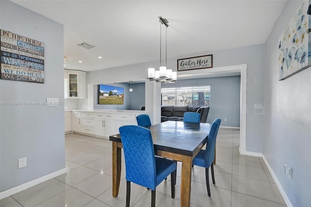 tiled dining room featuring an inviting chandelier