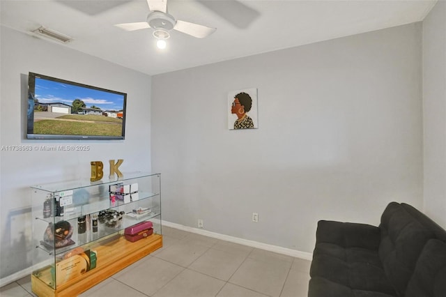 living area with light tile patterned floors and ceiling fan