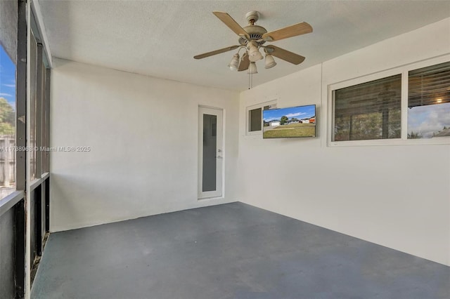 unfurnished sunroom with ceiling fan