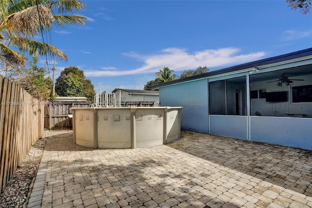 view of patio / terrace with ceiling fan and a pool