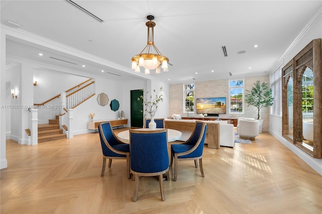 dining space featuring light parquet floors, ornamental molding, and an inviting chandelier