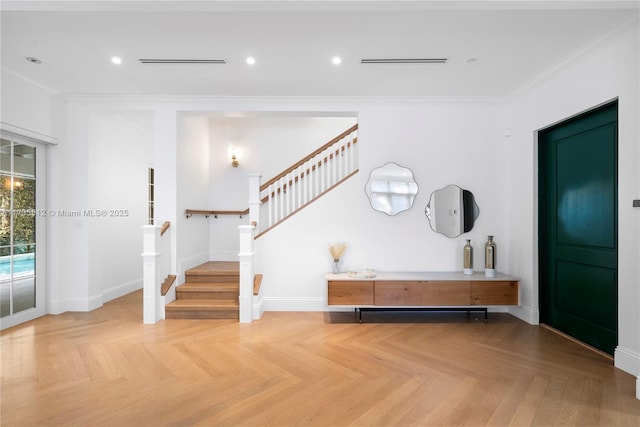 entrance foyer featuring ornamental molding and light parquet flooring