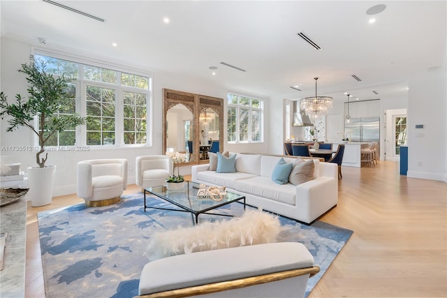 living area with arched walkways, a notable chandelier, recessed lighting, visible vents, and baseboards