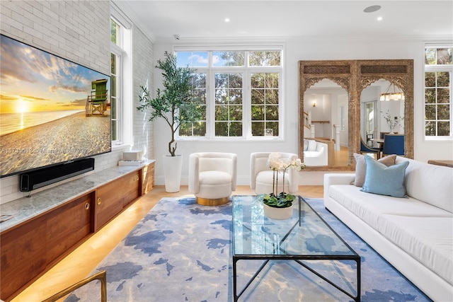 living room featuring crown molding and brick wall