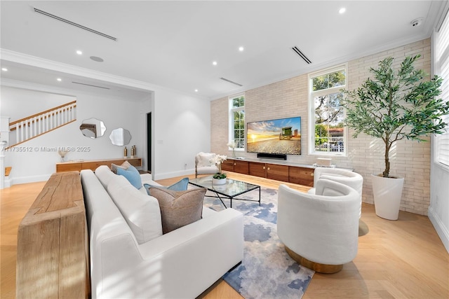 living room featuring crown molding, light parquet flooring, and brick wall