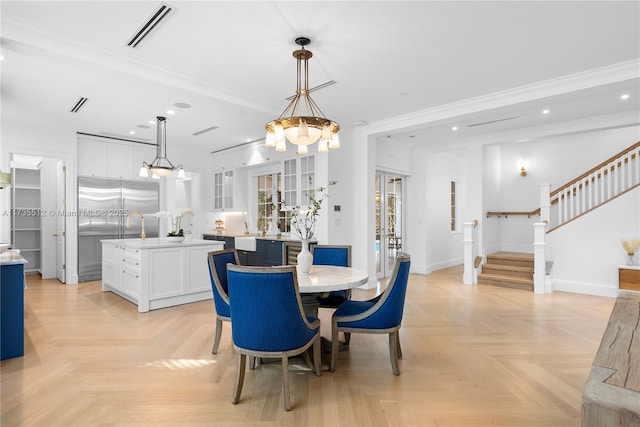 dining area featuring crown molding and light parquet flooring