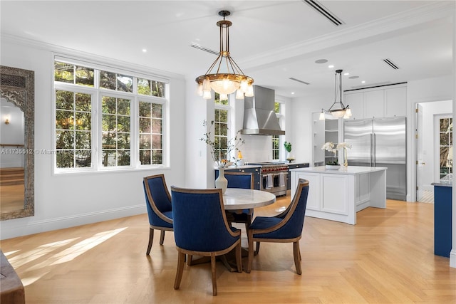 dining space featuring ornamental molding and light parquet flooring