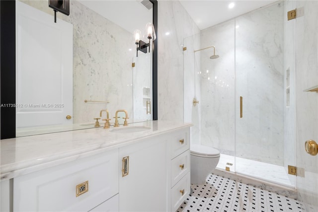 full bath with toilet, a marble finish shower, and vanity