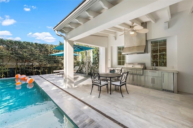 view of patio featuring an outdoor kitchen, area for grilling, sink, ceiling fan, and a fenced in pool