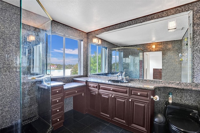 bathroom with vanity, tile patterned floors, a textured ceiling, and walk in shower