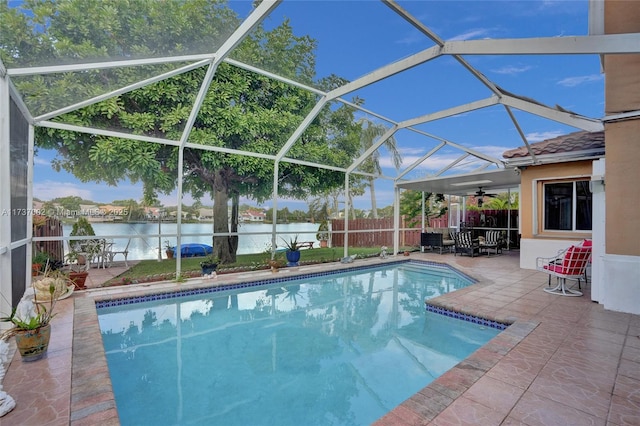 view of pool with a water view, ceiling fan, a lanai, and a patio area