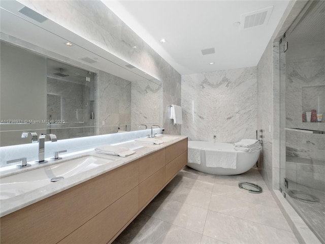 bathroom with tile walls, vanity, and independent shower and bath