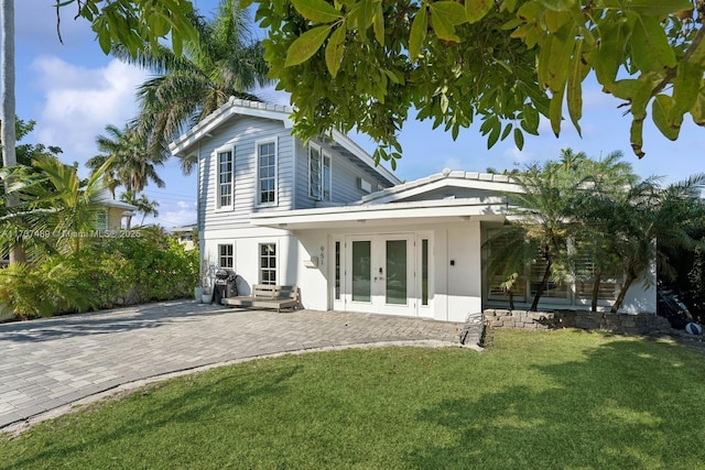 rear view of house with french doors and a yard