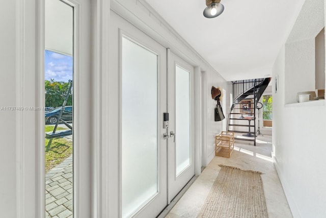 doorway to outside with concrete flooring and stairway