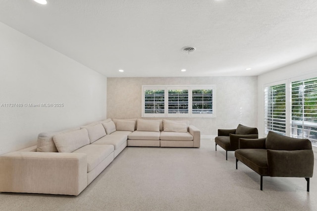 living room featuring light speckled floor, recessed lighting, visible vents, and a textured ceiling