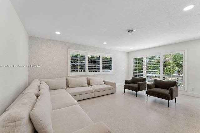 living room with recessed lighting, visible vents, and wallpapered walls