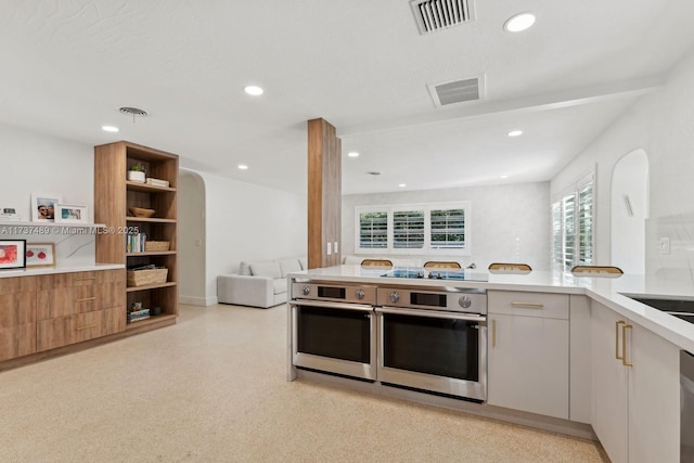 kitchen with visible vents, white cabinetry, open floor plan, light countertops, and modern cabinets