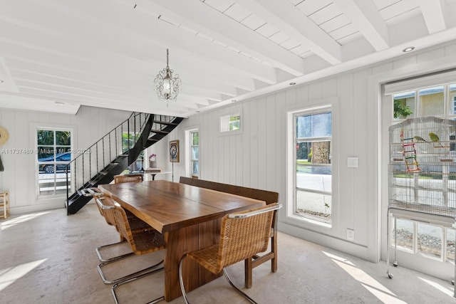 dining space with stairs, beamed ceiling, and concrete floors