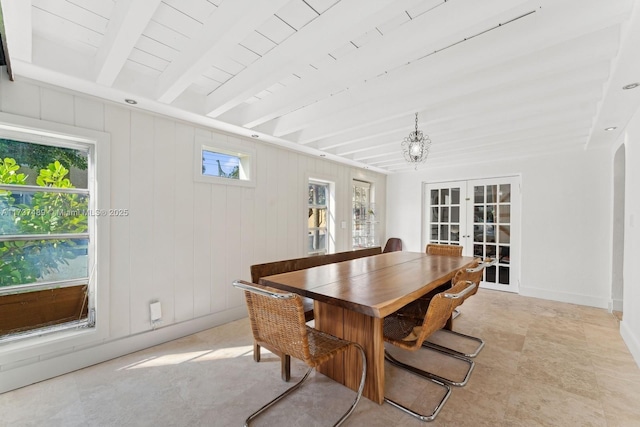 dining area featuring plenty of natural light, baseboards, beam ceiling, and french doors