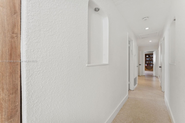 corridor featuring attic access and baseboards