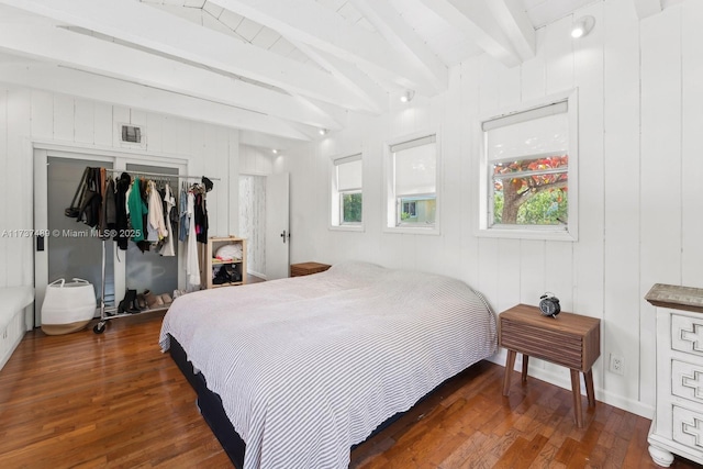 bedroom with lofted ceiling with beams, a closet, visible vents, and dark wood-type flooring