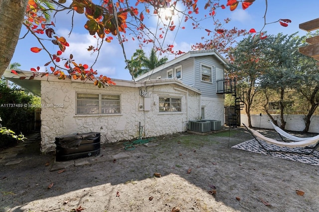 back of house with central AC and fence