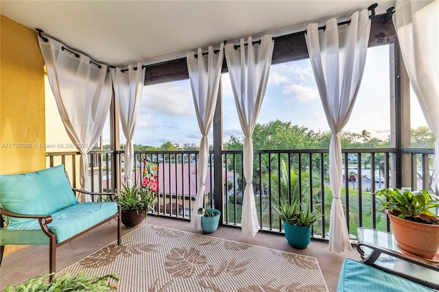 sunroom with expansive windows and carpet flooring