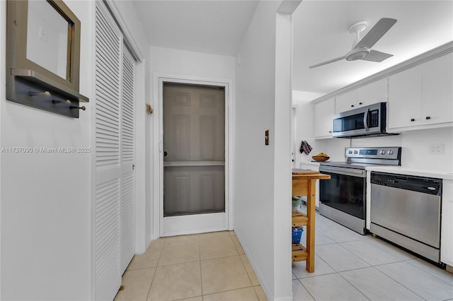 kitchen featuring appliances with stainless steel finishes, light countertops, white cabinetry, a ceiling fan, and light tile patterned flooring