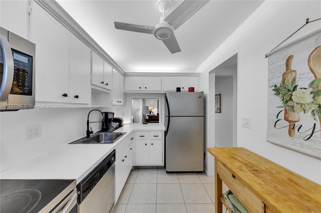 kitchen with white cabinets, a sink, appliances with stainless steel finishes, light countertops, and light tile patterned flooring
