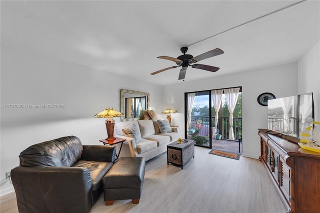 living room featuring light wood-style floors, a ceiling fan, and baseboards