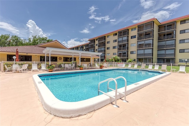 community pool with a patio and fence
