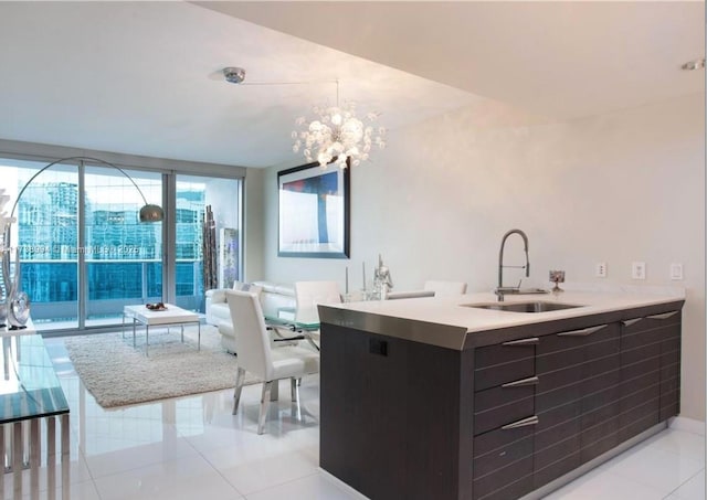 kitchen featuring light tile patterned flooring, an inviting chandelier, floor to ceiling windows, and sink