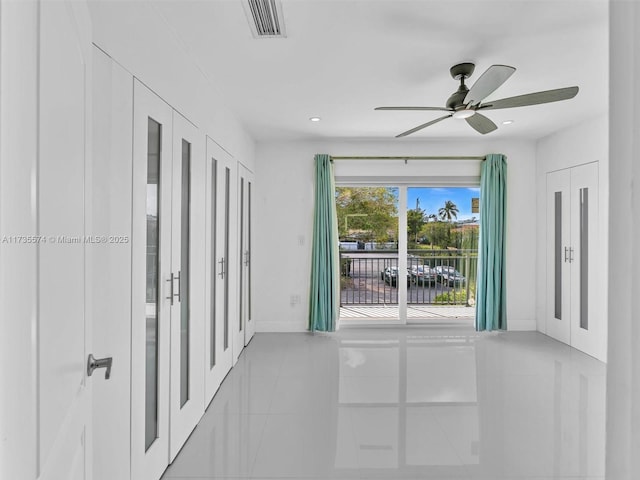 tiled empty room featuring ceiling fan