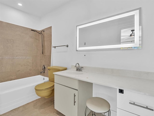 full bathroom with tiled shower / bath, vanity, ceiling fan, and toilet