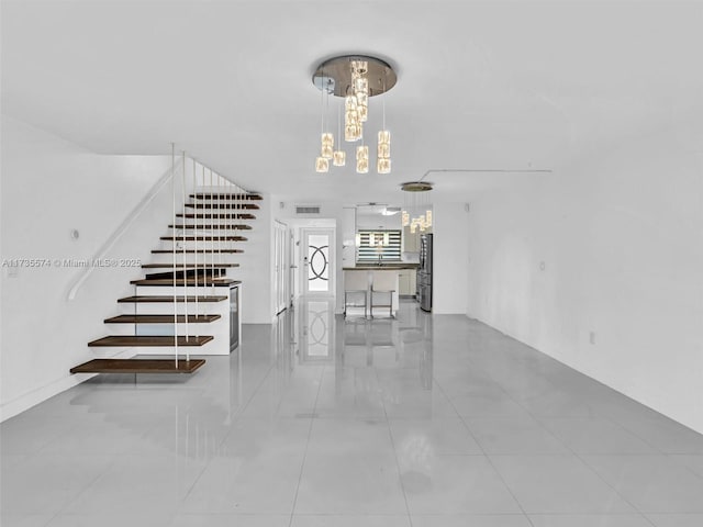 stairs with a chandelier