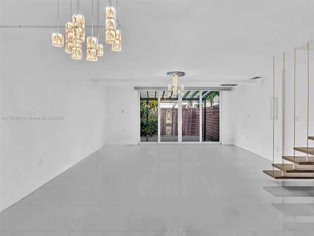 spare room with an inviting chandelier and light tile patterned floors