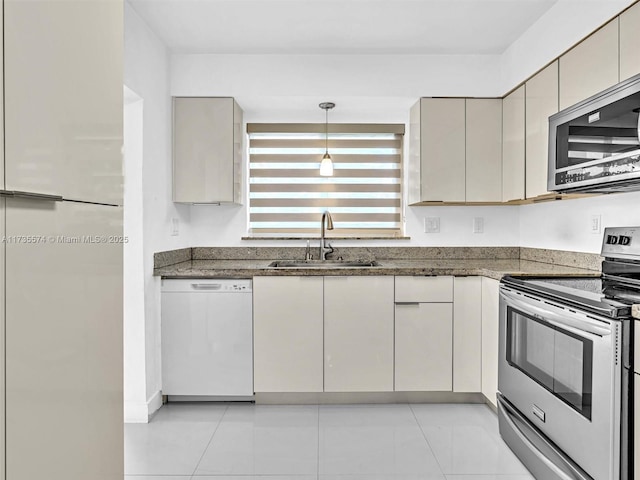 kitchen featuring pendant lighting, sink, dark stone countertops, light tile patterned floors, and stainless steel appliances