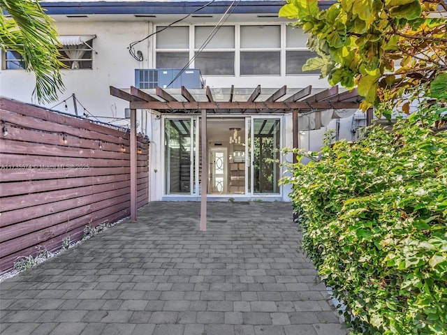 doorway to property with a pergola and a patio area