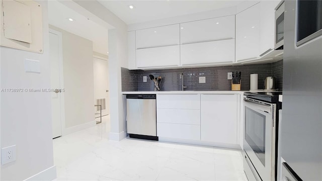 kitchen with tasteful backsplash, dishwasher, white cabinets, stove, and fridge