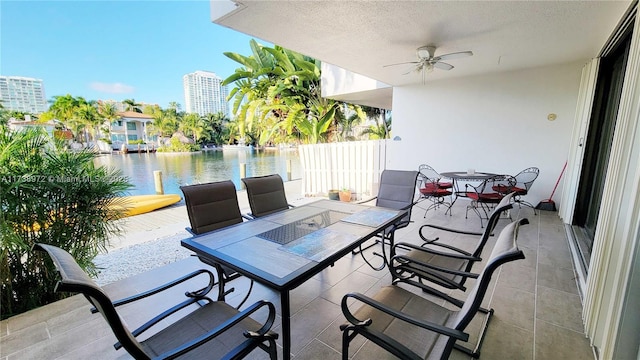 view of patio with a water view and ceiling fan