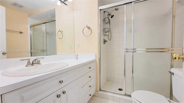 bathroom with vanity, a shower with shower door, and toilet