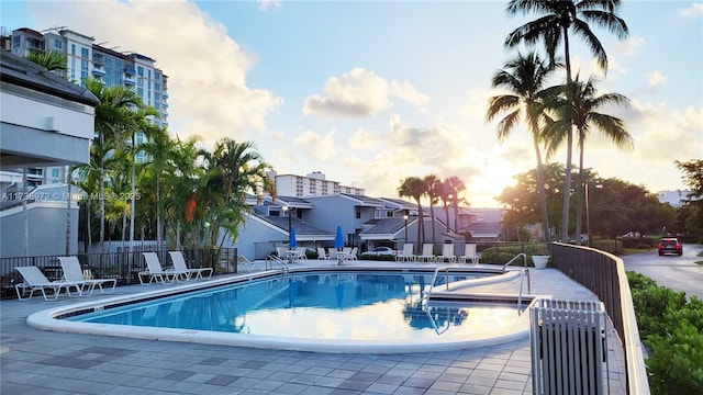 pool at dusk featuring a patio area