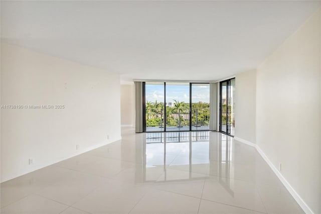 tiled spare room featuring expansive windows